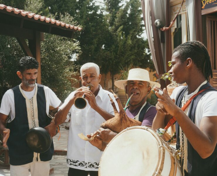 Four happy men are making human made music together.