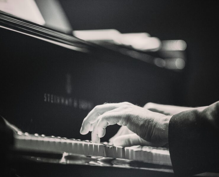 A person sitting on a grand piano playing.