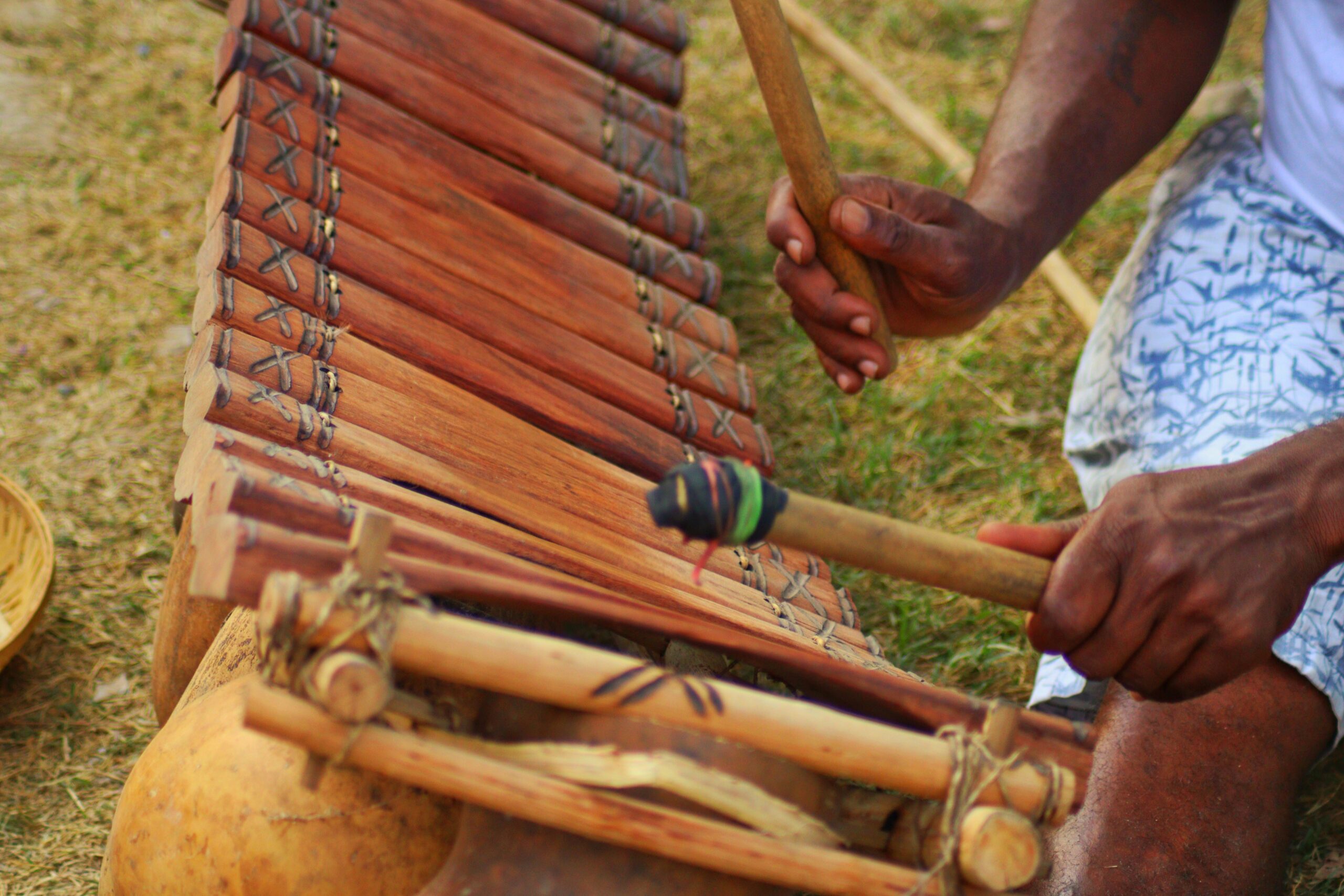 A person playing a traditional west african instrument: a balafon.