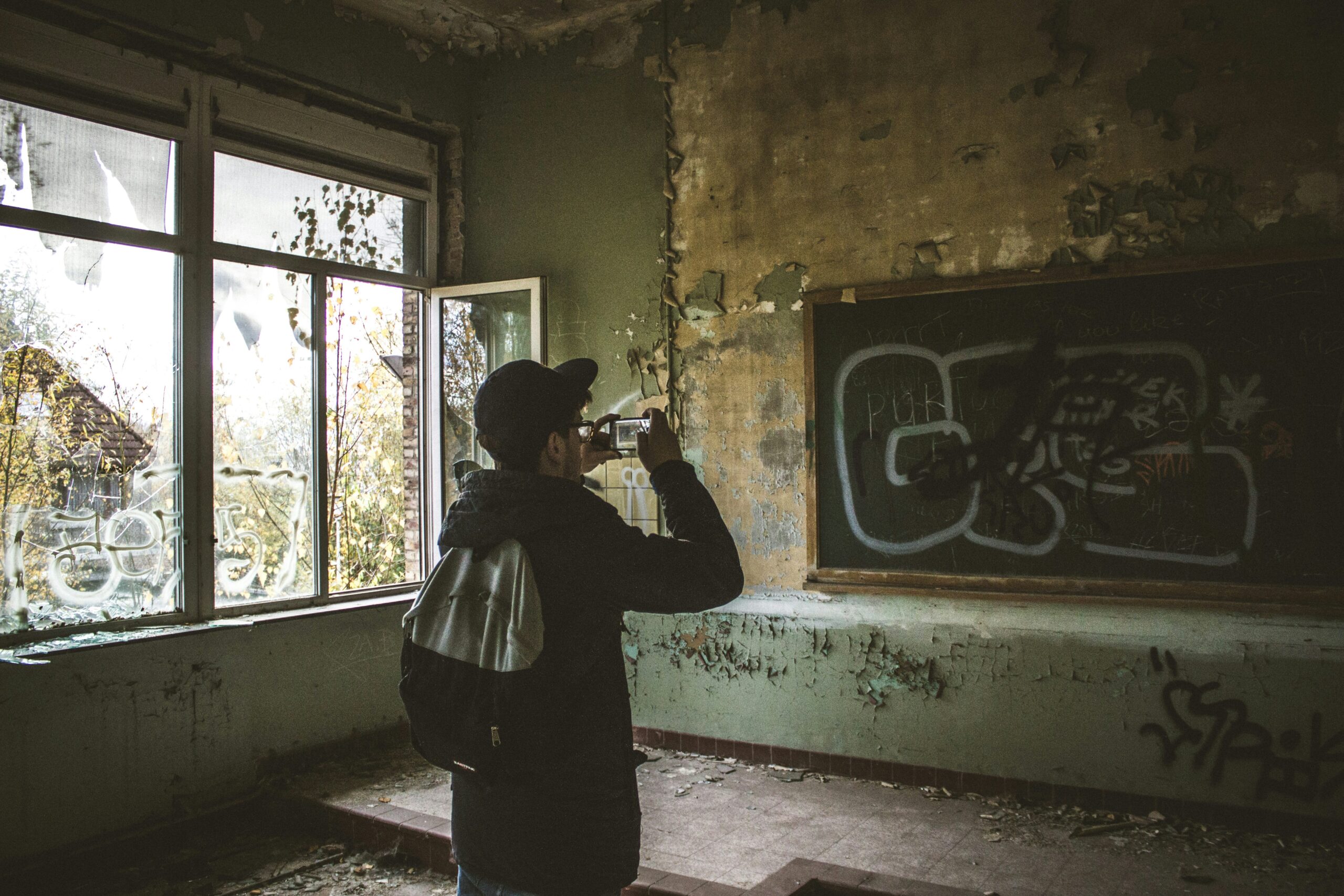 A YouTuber filming inside a lost place with his smartphone.
